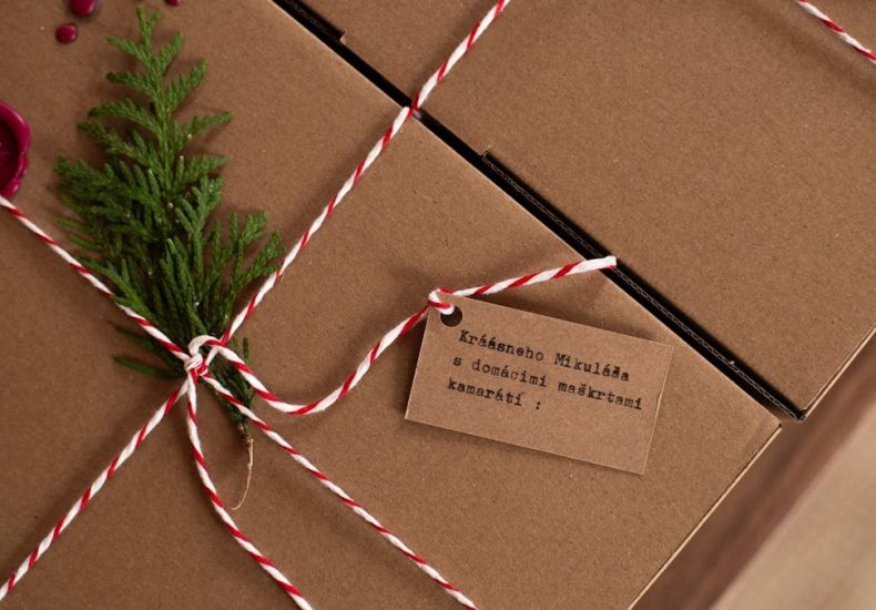 Rustic gift box tied with twine, adorned with a fir sprig and wax seal, perfect for holiday gifting.