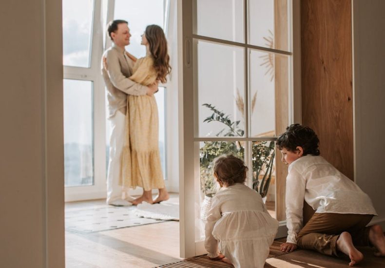 A joyful family moment indoors with parents and children enjoying a cozy home environment.
